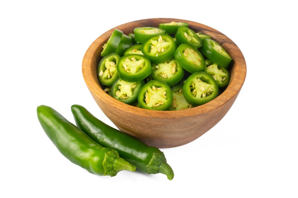 Fresh green jalapeno peppers on wooden table